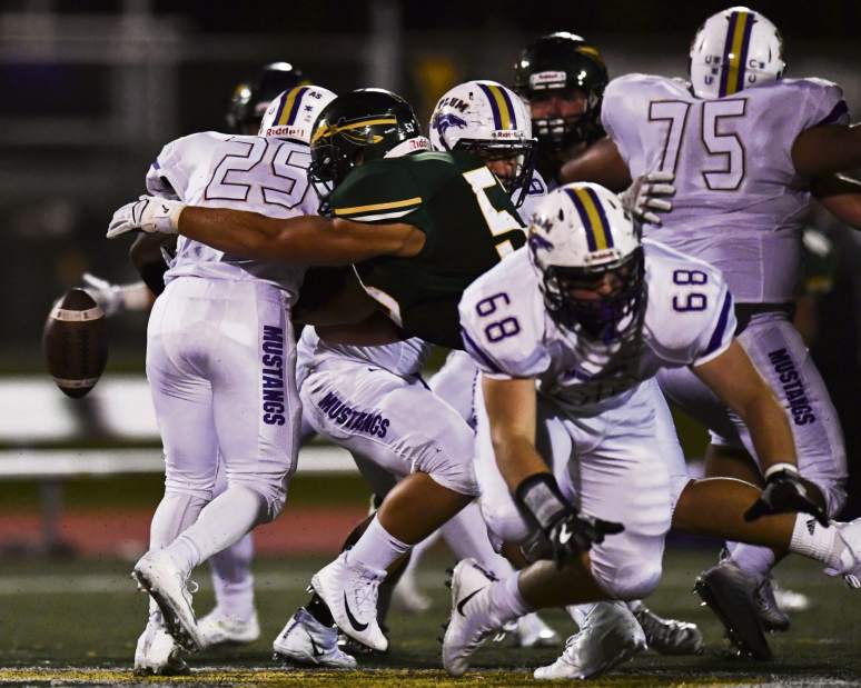 Penn-Trafford's Will Mayr (53) forces a fumbles on Plum's Marcus Thomas (25) in the third quarter of a WPIAL 5A conference game on Friday Sept. 08, 2017 at Penn-Trafford.