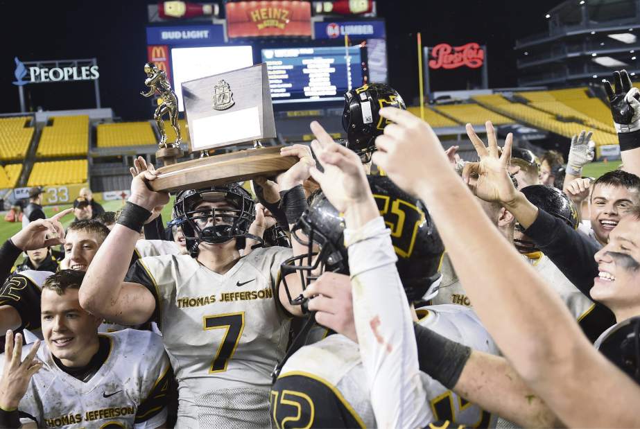 Thomas Jefferson's Noah Palmer (7) hoists the championship trophy with his teammates after defeating Montour, 27-0, in the WPIAL Class 4A final Saturday, Nov. 18, 2017, at Heinz Field.