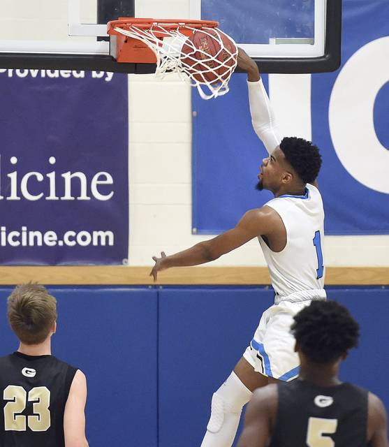 Woodland Hills Keandre Bowles dunks over Gateways William Kromka (23) and R.J. Stevenson during their game Friday, Dec. 14, 2018, at Woodland Hills.