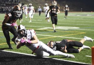 Peters Twp.’s Ryan Magiske lunges into the end zone to score past Bethel Park’s Fred Sauer (16) during the second quarter Friday, Oct. 18, 2019, at Bethel Park High School.