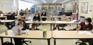 Students sit one to a table during a physical therapist assistant clinical practicum course class at Elgin Community College.