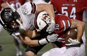 Peters Township’s Michael Peyton carries against Upper St. Clair’s Luke Banbury during the third quarter Oct. 1, 2020, at Peters..