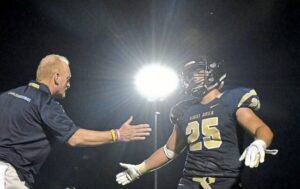 Kiski Area coach Sam Albert congratulates Drew DiNunzio-Biss after the senior scored the first touchdown at Richard J. Dilts Stadium on a 1-yard burst, leading the Cavaliers to a 24-9 victory over Allderdice on Aug. 24, 2018.