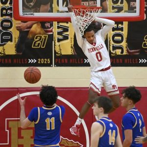 Penn Hills’ Aiden Thompson dunks over Hampton defenders during their game on Wednesday, Jan. 22, 2024, at Penn Hills. Penn Hills won, 51-46, in overtime.