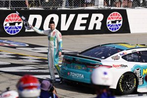 Denny Hamlin celebrates with the checkered flag after winning a NASCAR Cup Series race at Dover Motor Speedway in April 2024.