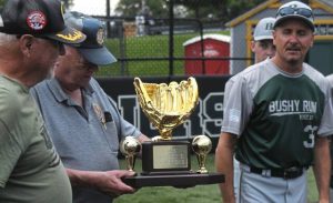 Bushy Run manager Scott Peyman (right) presents the District 31 American Legion baseball championship trophy to former Post Commander Jerry Brunson (center) and Dave Dudas to be on display at the Post.