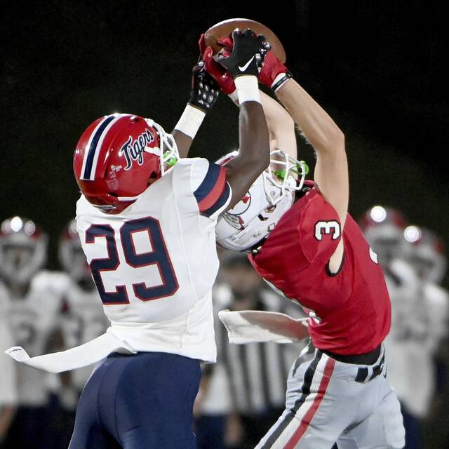 McKeesport’s Javien Robinson (left) battles for possession of a pass with Peters Township’s PJ Luke on Friday, Aug. 30, 2024, at Peters.