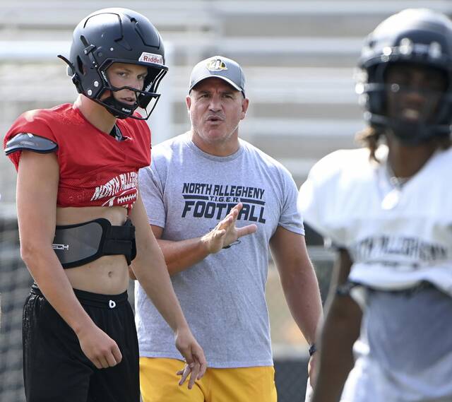 North Allegheny coach Art Walker Jr. talks with quarterback Brady Brinkley during practice on Monday in McCandless.