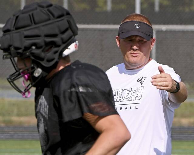 Quaker Valley head coach Tom Eshenbaugh works with his team during practice on Monday, Aug. 11, 2025, at Chuck Knox Stadium in Leetsdale.