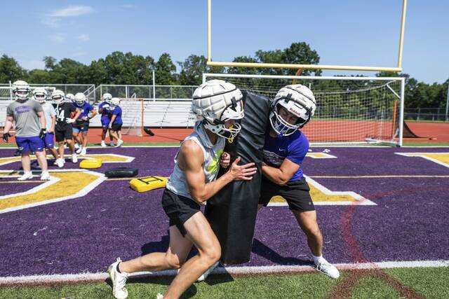 Plum’s Tyler Baleno, left, and Landen Ekiert, right, run defensive reps during team practice on Monday, Aug. 4, 2025 at Plum High School.