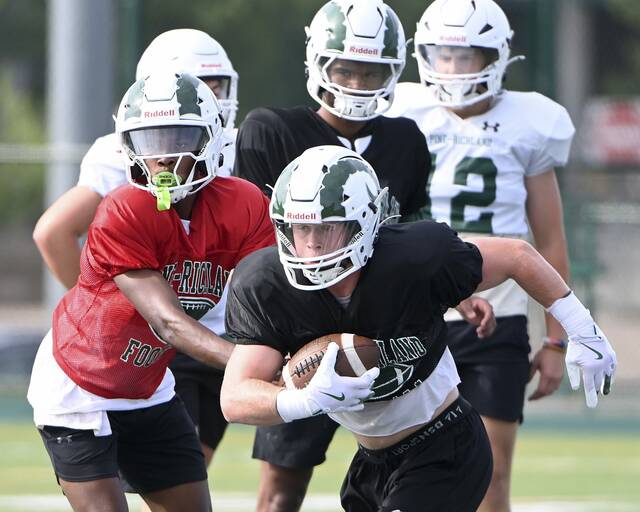 Pine-Richland’s Mac Miller takes a hand-off from quarterback Oobi Strader during practice on Monday, Aug. 4, 2025, in Pine.