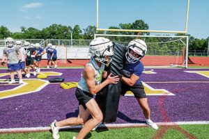 Plum’s Tyler Baleno, left, and Landen Ekiert, right, run defensive reps during practice Aug. 4 at Plum High School.