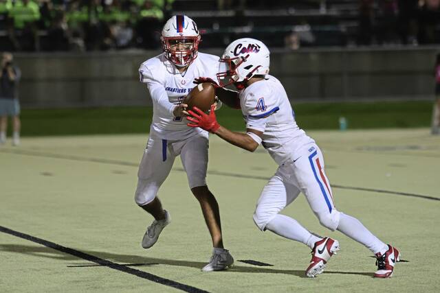 Chartiers Valley’s Tayshaun Lewis takes a handoff from Luke Miranda during a game against Belle Vernon last season.