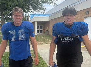 Senior Dylan Pitzer (left) and junior Aiden Piper head to the practice field Friday.
