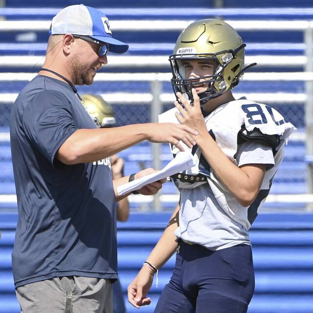 McGuffey head coach Nate Parry talks with quarterback Dakota Reedy during practice on Monday, Aug. 11, 2025, at Highlanders Stadium.