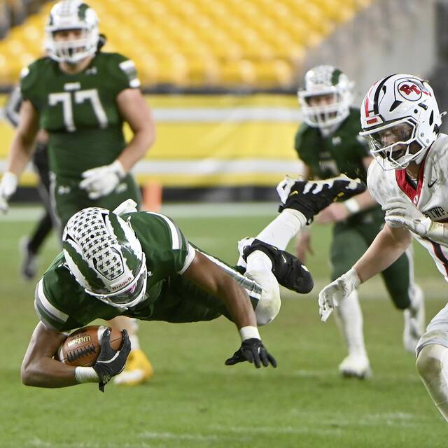 Pine-Richland’s Jay Timmons dives for extra yardage past Peters Township’s Nolan DiLucia during the WPIAL Class 5A championship game Nov. 23, 2024, at Acrisure Stadium.