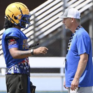 West Mifflin’s Armand Hill talks with head coach BJ Pugh during practice on Aug. 7 at Titan Stadium in West Mifflin.