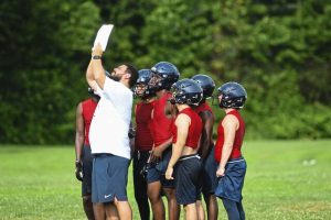 Summit Academy football coach Anthony Becoate works with his team during a 7-on-7 scrimmage July 25, 2025, at Springdale.