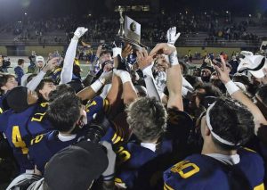 Central Catholic celebrates with the trophy after beating North Allegheny in the WPIAL Class 6A championship Nov. 16, 2024, at Norwin High School.
