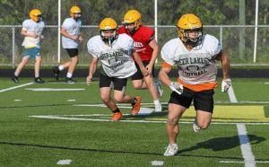 Deer Lakes running back Ryan Love (front) leads the charge in a pursuit drill during practice Aug. 6.