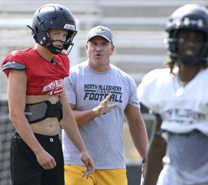 North Allegheny head coach Art Walker Jr. talks with quarterback Brady Brinkley during practice on Monday, Aug. 4, 2025, in McCandless.