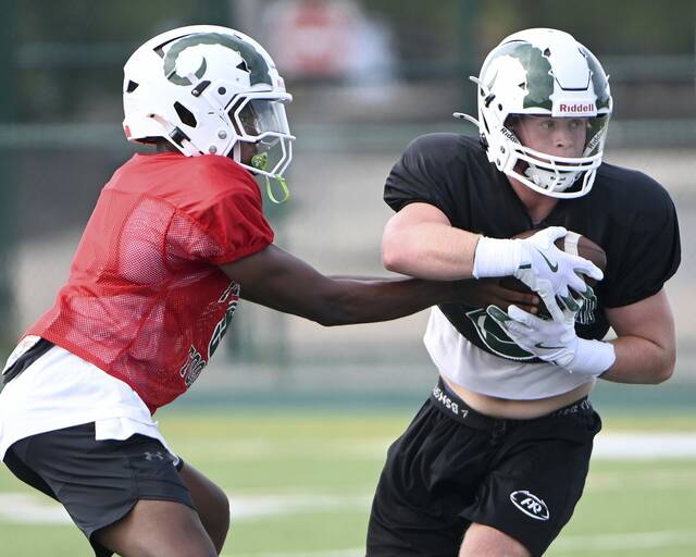 Pine-Richland’s Mac Miller takes a handoff from quarterback Oobi Strader during practice Aug. 4 in Pine.