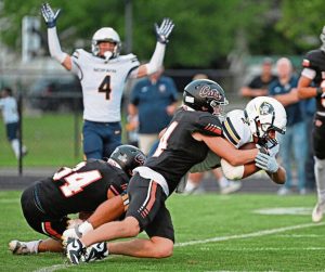Norwin’s Giovanni Rothrauff drags Latrobe’s Dom Angelicchio and Sawyer Butina (4) last Friday.