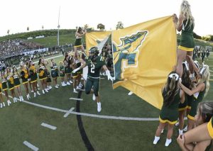 Penn Trafford’s Colton Tyburski breaks through the banner as the Warriors get ready to play Norwin on Aug. 22.