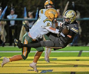 Freeport’s Owen Neistein hangs on to a touchdown pass as he’s hit by Deer Lakes’ Colby Borowski on Friday.