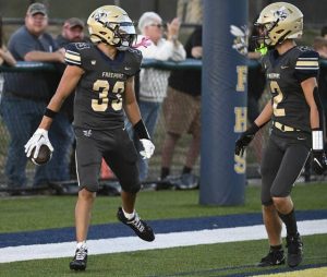 Freeport’s Bryson Page celebrates with Amos Glenn after Glenn’s first-quarter touchdown against Deer Lakes on Friday.