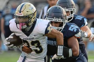 Freeport running back Amos Glenn (33) drags Burrell's Weston Baronie (50) as he fights for more yards on Friday, Sept. 19, 2025, at Burrell High School.
