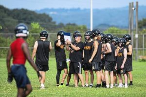 Springdale coach Chad Walsh works with his team during a 7-on-7 scrimmage against Summit Academy on July 25 at Springdale.