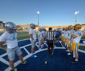 Hempfield (left) and Canon-McMillan players gather for the coin toss before playing Friday.