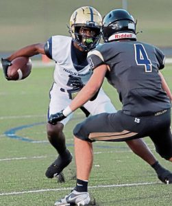 Franklin Regional Jaymeir Austin looks to get around Kiski Area defensive back Andrew Finney during the first quarter Friday night at Richard J. Dilts Field.