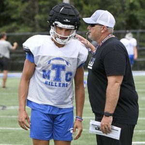 Trinity head coach Dan Knause calls a fade pass in the end zone with quarterback Jonah Williamson during practice on Friday, Aug. 9, 2024, in North Franklin.