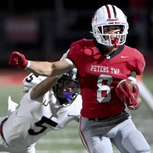 Peters Township’s Cole Neupaver carries past Upper St. Clair’s Caffery Duplessis last Friday.