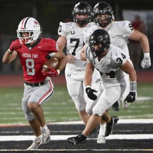 Peters Twp.’s Cole Neupaver breaks away from Upper St. Clair defenders during their game on Friday, Sept. 26, 2025, at Peters.