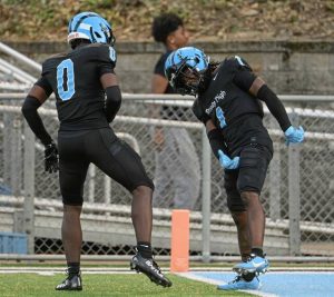 Woodland Hills’ Scoop Smith (right) celebrates with Malik McCloud after scoring a first-quarter touchdown against Penn-Trafford on Sept. 12.