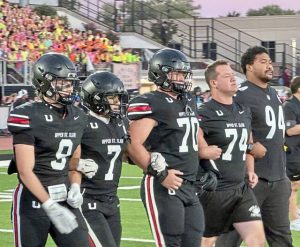 Captains from Upper St. Clair, with Steelers defensive lineman Yayha Black, head to midfield for the coin toss before playing South Fayette on Oct. 3, 2025, at Upper St. Clair.