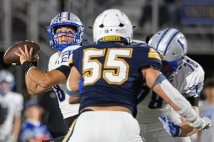 Hempfield quarterback Dominic Detruf (left) looks for room to pass Friday, Oct. 3, 2025, at Norwin.