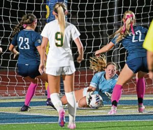 Penn-Trafford keeper Alannah Hall makes a save as Norwin’s Tatum Casper (23) and Hannah Amantea pressure her Monday.
