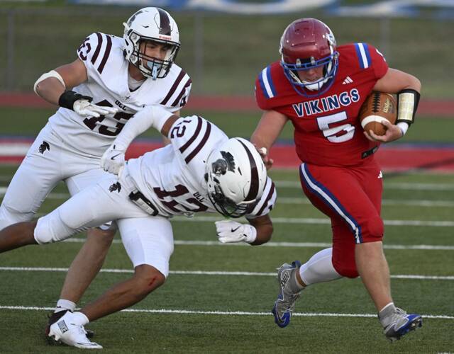Mt. Pleasant’s Dane Firmstone stiff-arms Greensburg Central Catholic’ Samir Crosby on Aug. 29.