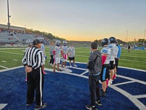 Hempfield and Seneca Valley players and coaches watch the coin toss Friday night at Spartan Stadium.