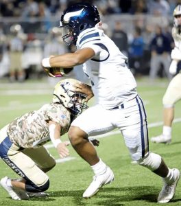 Hopewell quarterback James Armstrong attempts to stiff arm a Freeport defender Friday night.