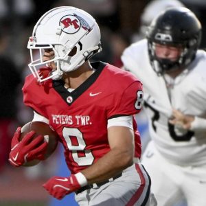 Peters Township’s Cole Neupaver carries the ball against Upper St. Clair on Sept. 26.