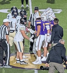 Players from Kiski Area and Plum meet at midfield for the coin toss before their game Oct. 17, 2025, at Plum