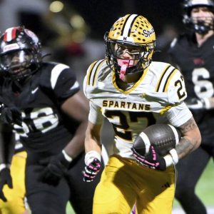 Montour’s Caden Halajcio eludes Aliquippa defenders en route to a fourth quarter touchdown Friday night.