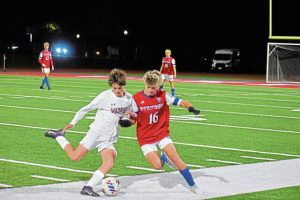 Elizabeth Forward’s Vincenzo Ricciardi (left) and Mt. Pleasant’s Landon Stuart (16) converge on the ball during a WPIAL Class 2A first-round playoff match Monday.