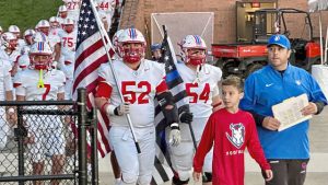 Brady Schaming (52) and Joel Buerkle (54) lead Chartiers Valley onto the field before a game against Trinity on Oct. 10.
