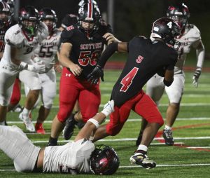 Elizabeth Forward’s Jaydyn Clark tries to drag down Southmoreland’s Averyon Darnell by his jersey Oct. 17.